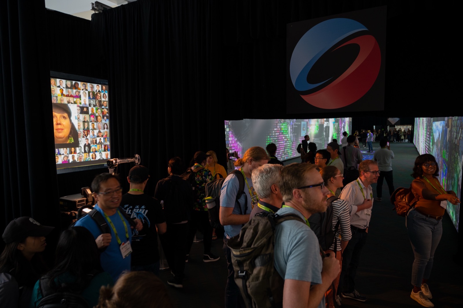 A grid of conference attendee portraits on a screen near the entrance, with the SIGGRAPH 50th anniversary logo overhead